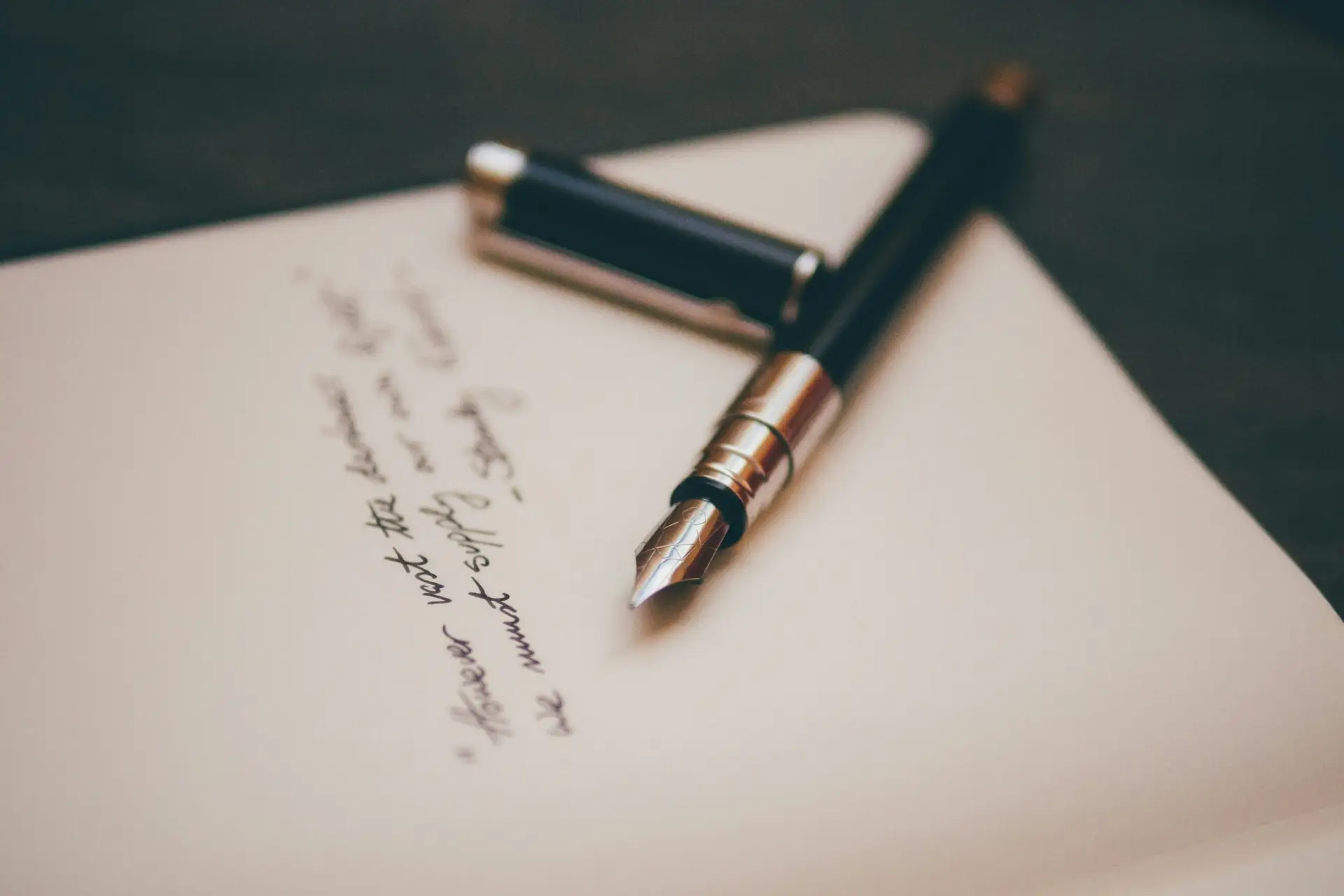 stylo plume élégant ouvert sur une feuille de papier avec début de texte rédigé