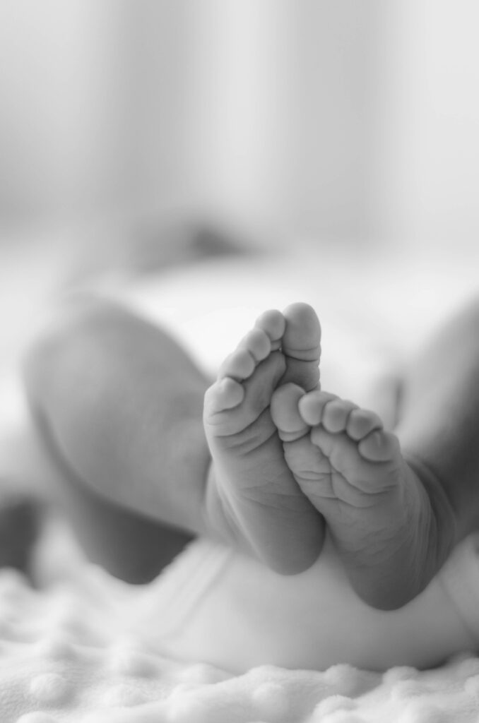photographie en noir et blanc de pieds de bébé